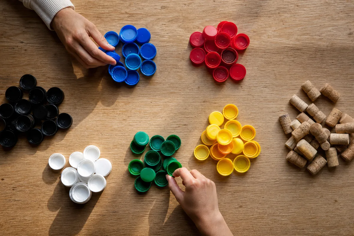 Bouchons plastique triés par couleur sur une table en bois lors d&rsquo;un tri associatif